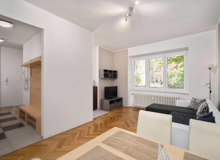 Wohnzimmer mit Sofa, Esstisch und Flur in einer 3-Zimmer-Wohnung.