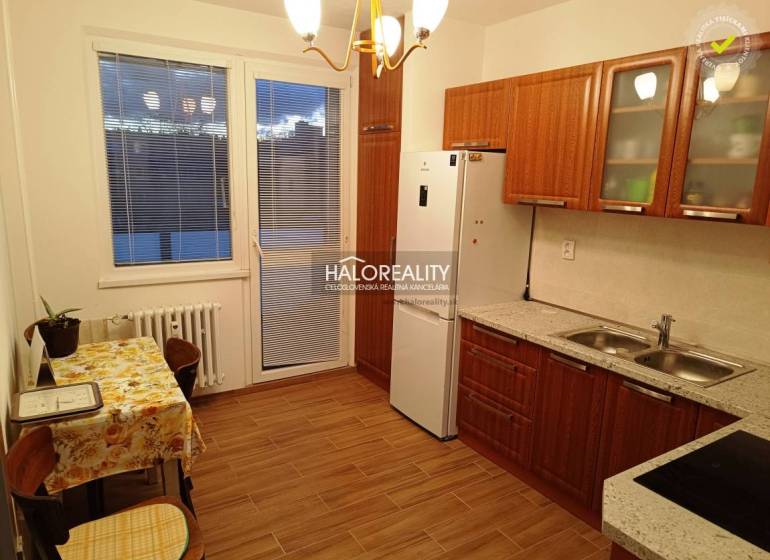 Küche und Raum in einer 2-Zimmer-Wohnung mit Holzküchenzeile und Tisch.