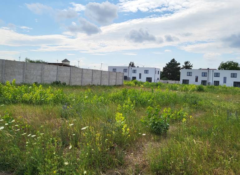 Grundstücke - Wohnen in Potzneusiedl, umgeben von Grünflächen und modernen Gebäuden im Hintergrund.
