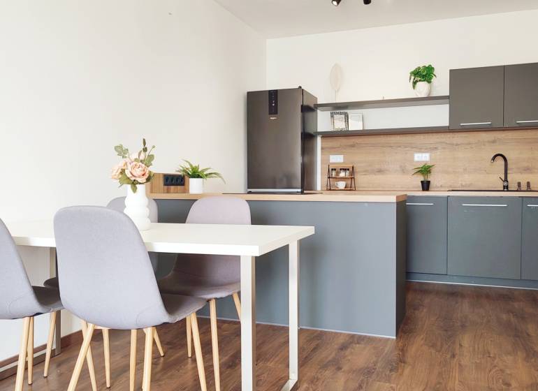 Küche mit Esstisch und Stühlen, 2-Zimmer-Wohnung mit Holzboden und Dekoration.