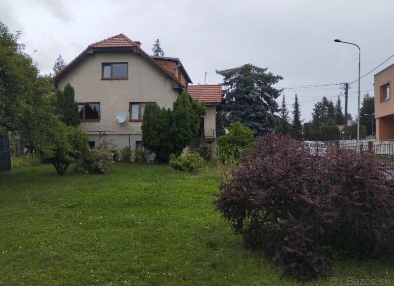 Ein Einfamilienhaus in Martin, mit einem gepflegten Garten und umgeben von Bäumen und Sträuchern.