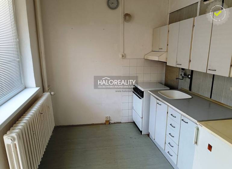 Küche in einer Einzimmerwohnung mit Herd, Spüle und Küchenschränken.