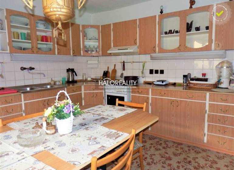 Eine Küche in einem Einfamilienhaus mit einer Holzarbeitsplatte, einem Esstisch und Blumendekoration.