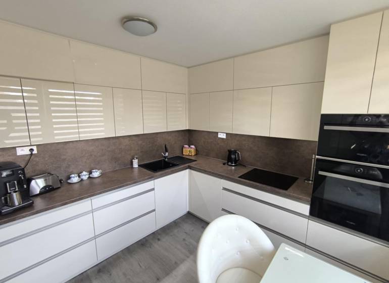 Küche in einer 3-Zimmer-Wohnung, moderne Küchenzeile und Geräte, helle Farbtöne.