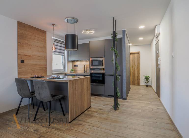 Stilvolle Küche in einer 3-Zimmer-Wohnung mit Holz- und grauen Akzenten.