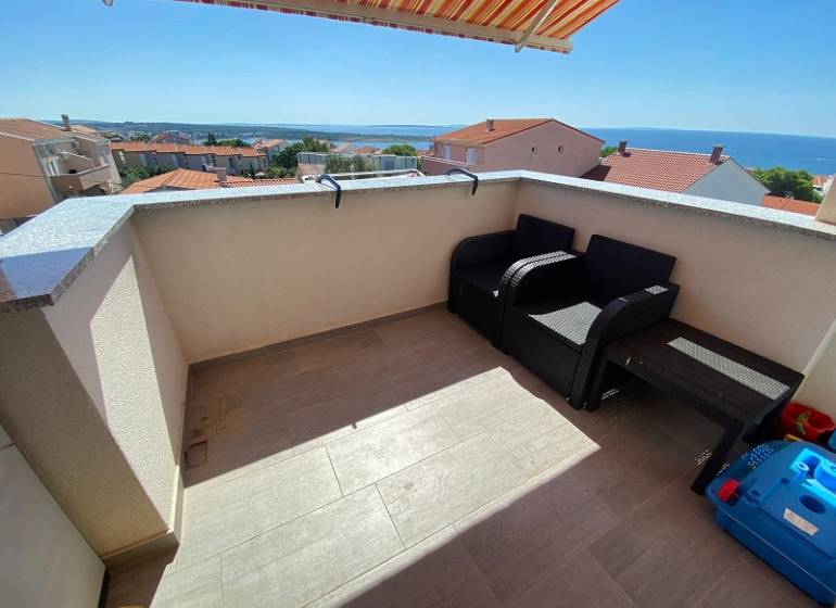 Zweizimmerwohnung in Novalja, Terrasse mit Meerblick, zwei Sessel, Tisch.