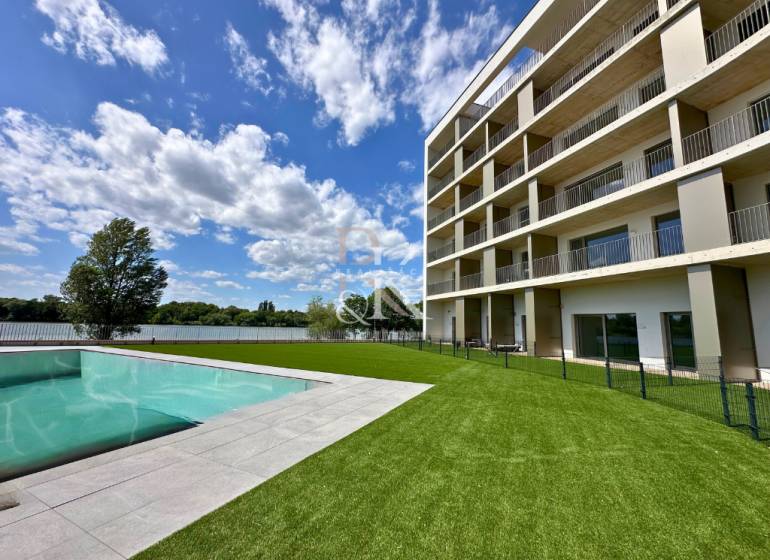 Ein Gebäude mit Pool und gepflegtem Rasen am Wasser in Banka, ideale Lage.