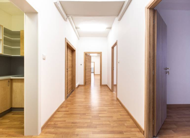 Flur mit Holzboden und Bürotüren.