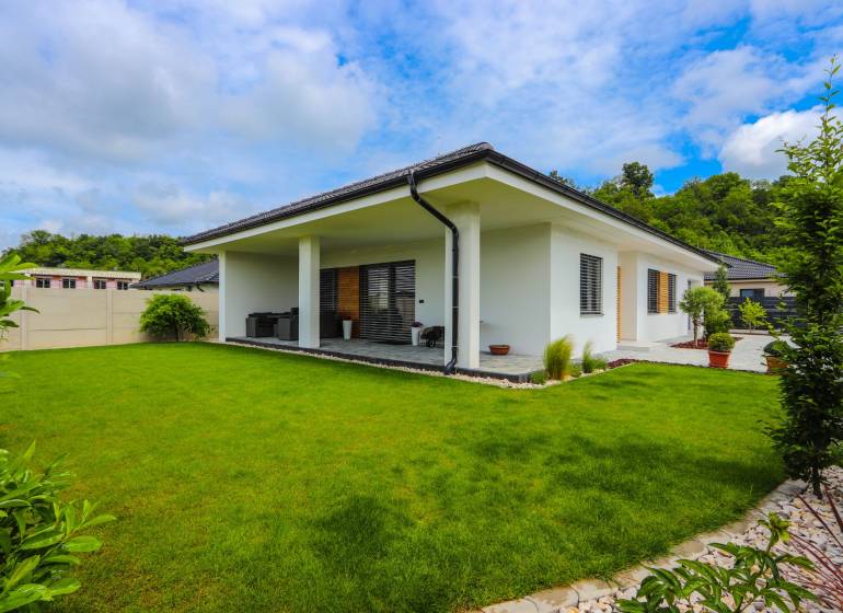 Ein Einfamilienhaus in Piešťany mit einer verglasten Terrasse und einem grünen Rasen.