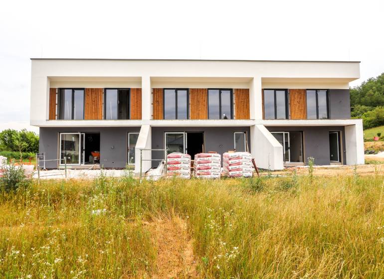 Ein Einfamilienhaus in Piešťany mit großen Fenstern, zwei Etagen und einem im Bau befindlichen Garten.
