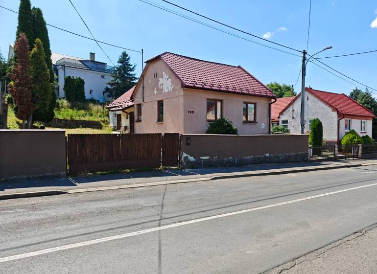 Ein Einfamilienhaus in der Dlha-Straße in Vranov nad Topľou mit einem roten Dach und einem Holzzaun.
