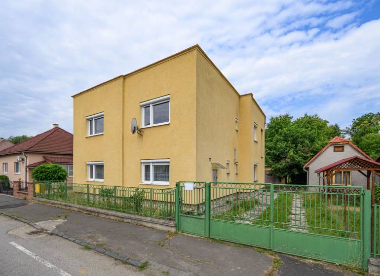 Gelbes Einfamilienhaus mit Garage und Garten in der Stadt Vidiná.