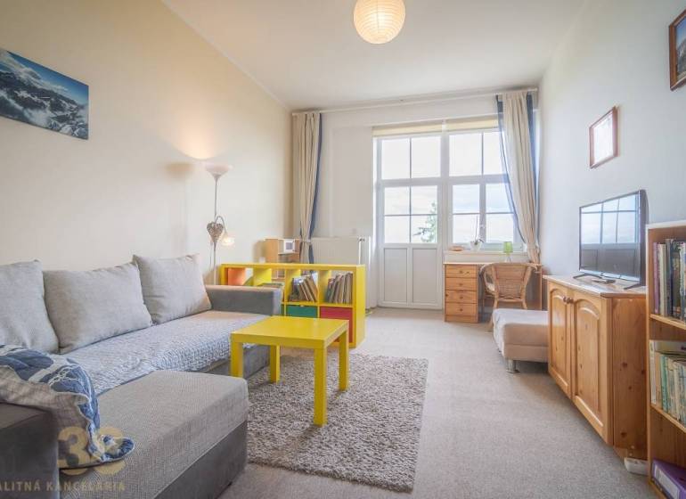 Wohnzimmer mit hellem Sofa und gelbem Tisch in einer 3-Zimmer-Wohnung.