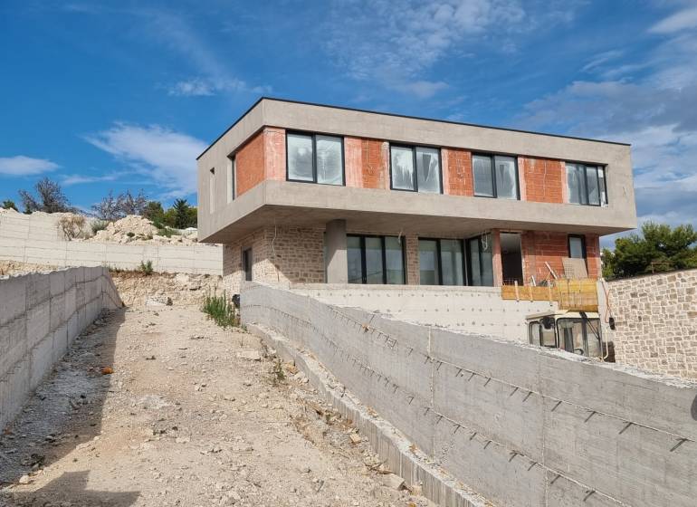Eine im Bau befindliche Villa in Vodice mit einer Betonterrasse und modernen Fenstern.