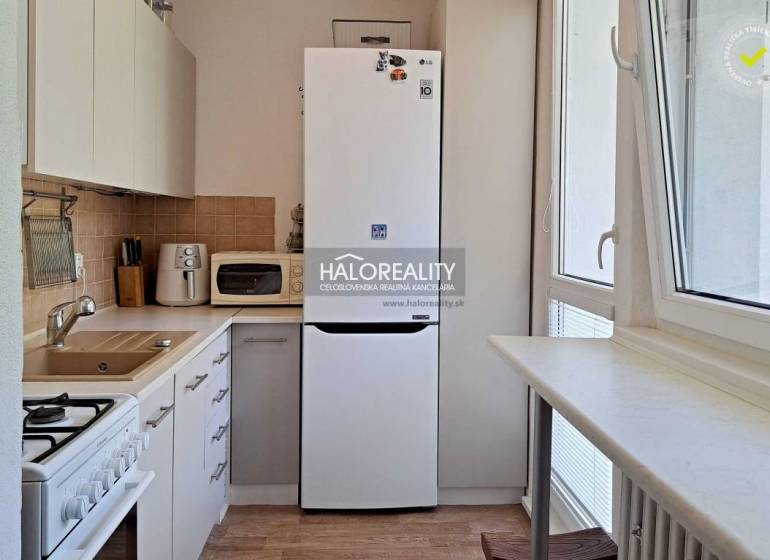 Küche in einer 3-Zimmer-Wohnung mit Kühlschrank, Mikrowelle und Herd.