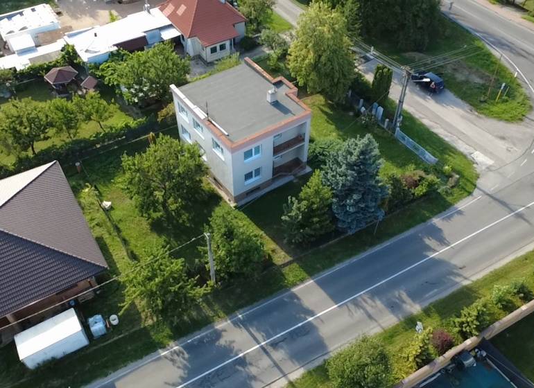Ein Einfamilienhaus in Rakoľuby in Nové Mesto nad Váhom, umgeben von Grünflächen und einer Straße.