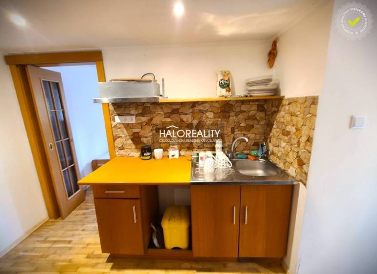 Eine Küche in einem Einfamilienhaus mit Holzmöbeln und Steinverkleidung.