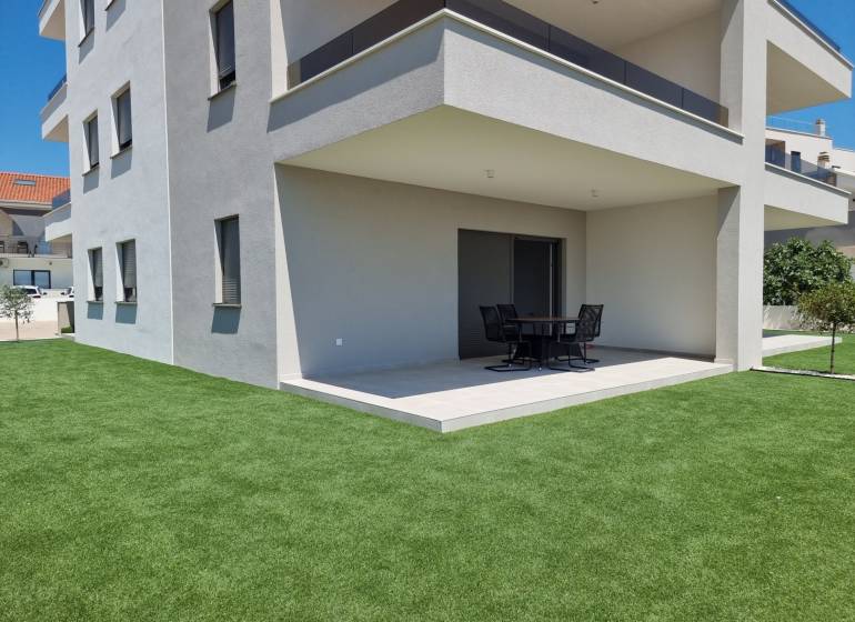 Exterieur einer 4-Zimmer-Wohnung in Vodice mit moderner Terrasse und grünem Rasen.