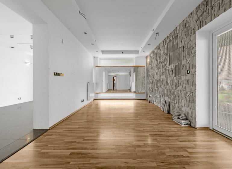 Gewerberäume mit Holzboden und Steinwand, geeignet für verschiedene Nutzungen.