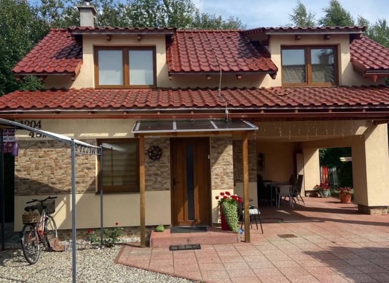Ein Einfamilienhaus in Liptovská Ondrašová in Liptovský Mikuláš mit einem roten Dach und einem Gartenpavillon.