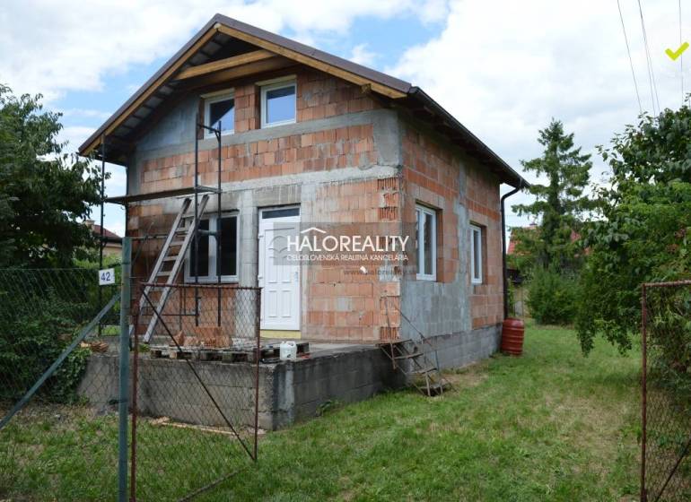 Eine Hütte in Vinosady, gebaut aus Ziegeln, mit einer Leiter und grüner Umgebung.