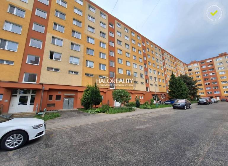 Ein Wohnblock mit 3-Zimmer-Wohnungen in Prievidza, umgeben von Grünflächen und einem Parkplatz.
