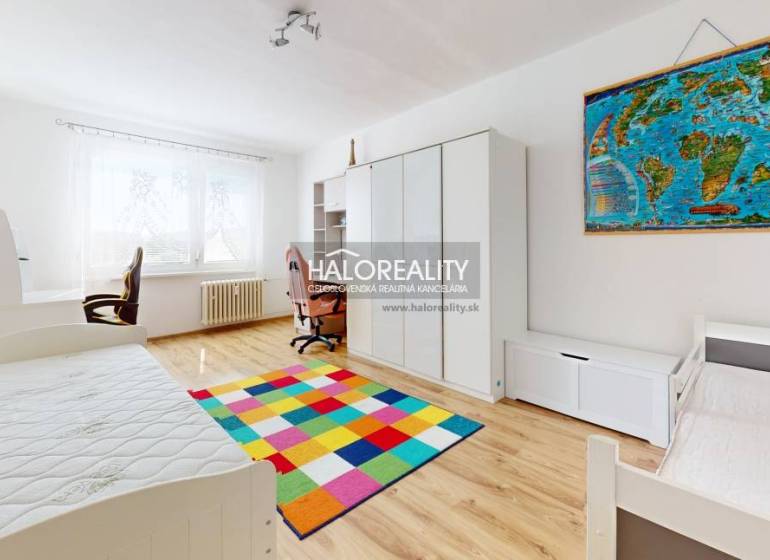 Kinderzimmer in einer 3-Zimmer-Wohnung mit einem bunten Teppich und einem Schreibtisch.