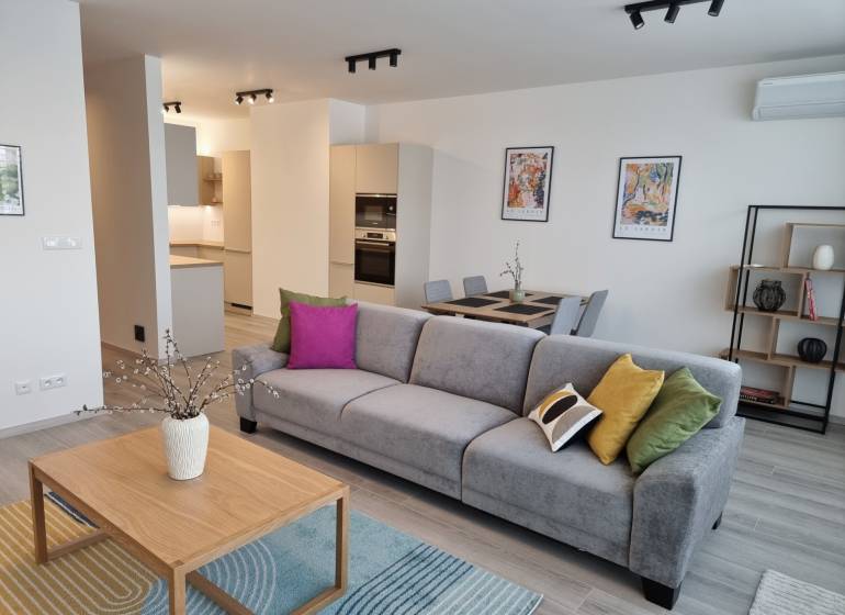 Wohnzimmer mit Sofa, Esstisch und Küche in einer 3-Zimmer-Wohnung.