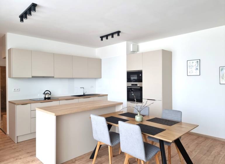 Küche in einer 3-Zimmer-Wohnung mit Holztisch und modernen Geräten.