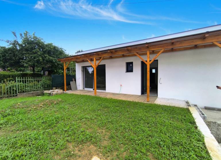 Ein Einfamilienhaus in Malé Kršteňany mit Garten und Holzterrasse.