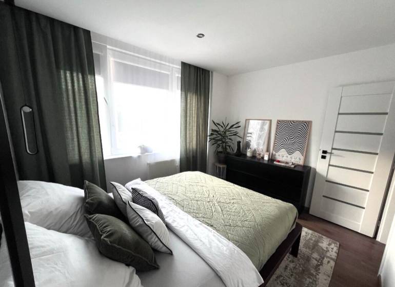 Schlafzimmer in einer 4-Zimmer-Wohnung mit stilvollem Dekor und Möbeln.