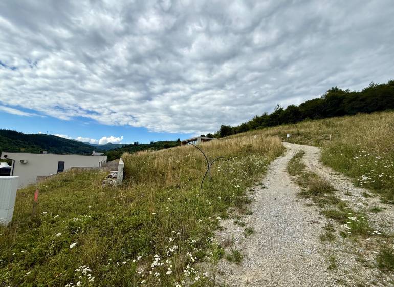 Grundstücke - Wohnen in Divinka mit ländlicher Straße und Panoramablick auf die Landschaft.