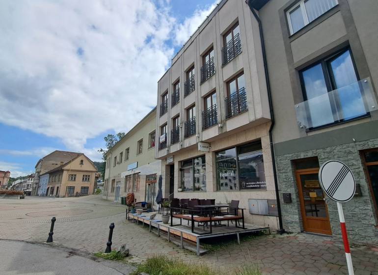 Das Gebäude in der Mostová-Straße in Ružomberok mit Terrasse und umliegenden historischen Bauwerken.
