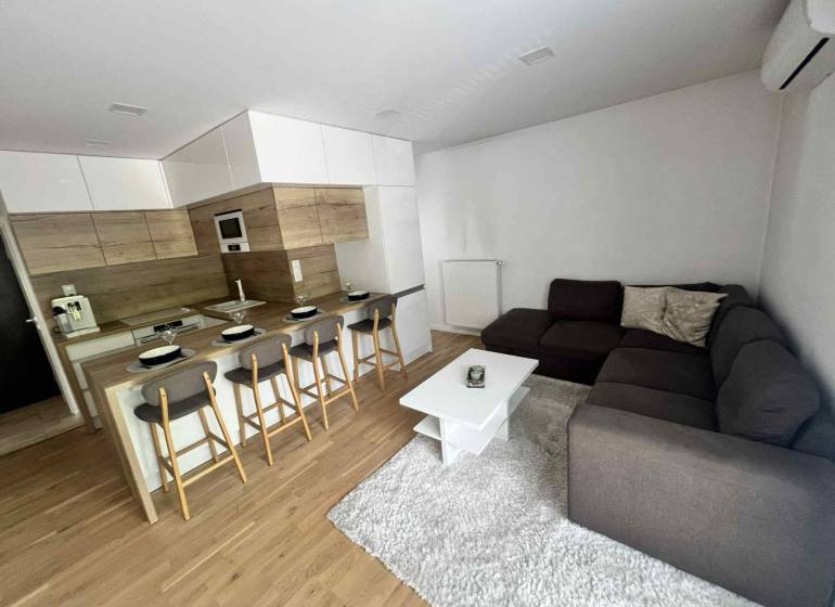 Wohnzimmer in einer 3-Zimmer-Wohnung mit Küche, Bartresen und Ecksofa.