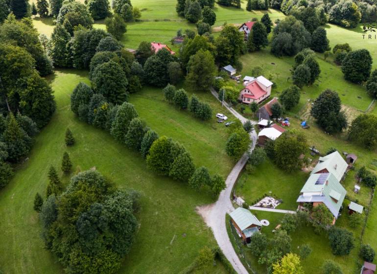 Luftaufnahme von Erholungsgrundstücken in Oščadnica, umgeben von dichtem Grün und Häusern.