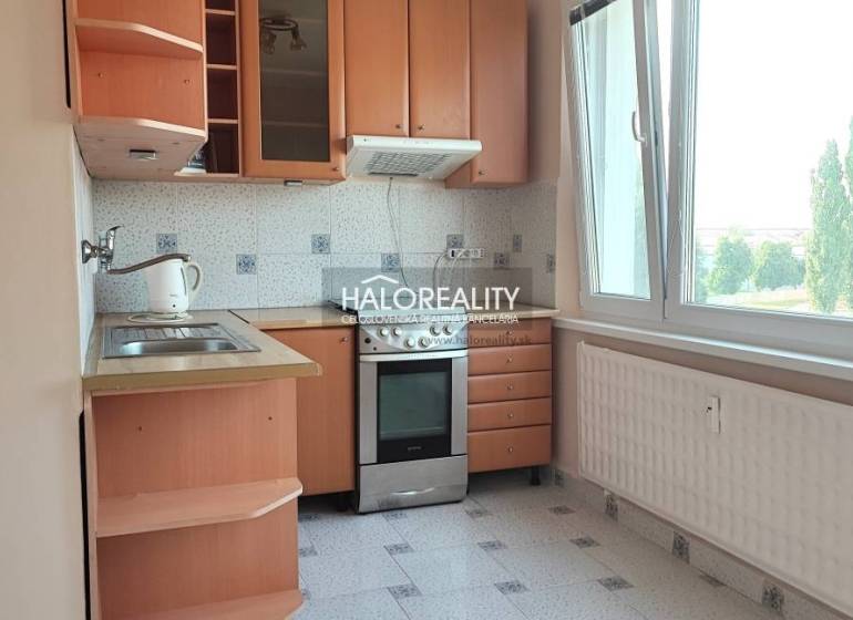 Küche in einer 4-Zimmer-Wohnung mit Holzschränken und großem Fenster.
