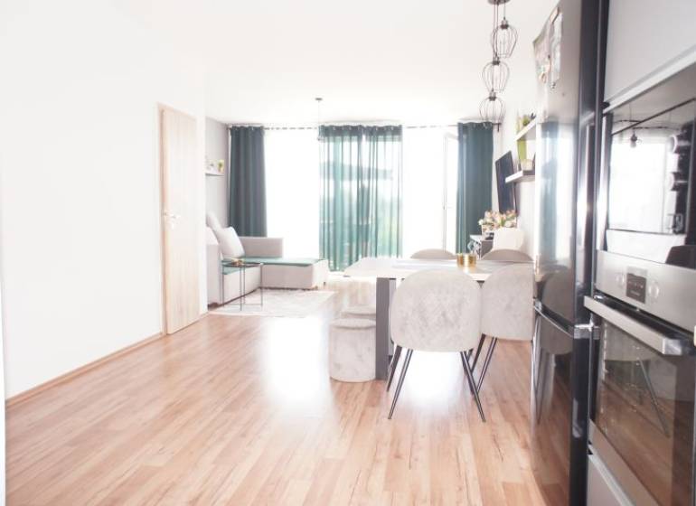 Obývací Zimmer in einem Einfamilienhaus mit Esstisch und Küchenzeile.