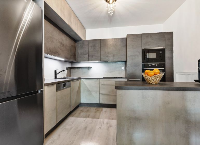 Moderne Küche mit Kühlschrank, Geschirrspüler und Bartheke in einer 3-Zimmer-Wohnung in der Vukovarská-Straße.