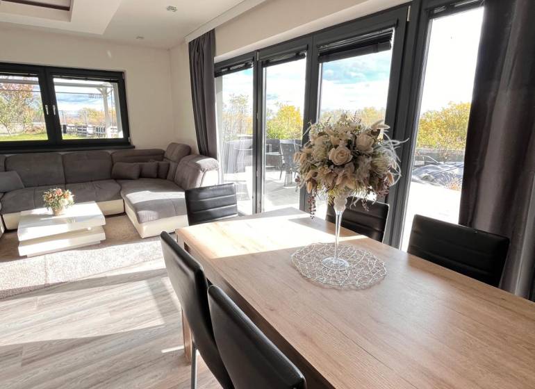 Wohnzimmer eines Einfamilienhauses mit Holzboden und komfortabler Sitzgelegenheit.