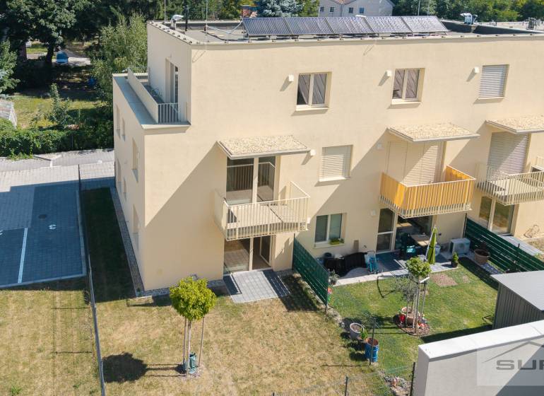 Gelbes Wohnhaus in der Železničná-Straße in Bratislava-Vrakuňa mit Garten und Parkplätzen.