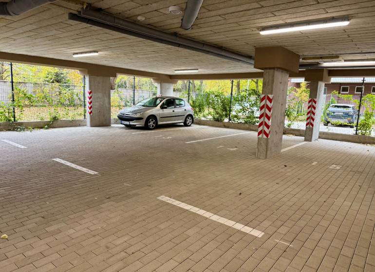 Geräumiges Parken in den Garagen in der Sadová-Straße in Senica mit Auto und Säulen.