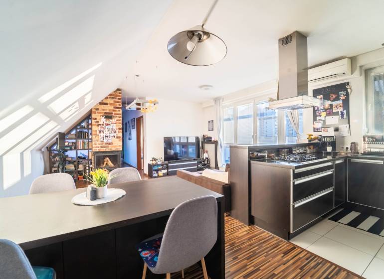 Küche mit Fernseher, Kamin und Holzboden in einer 2-Zimmer-Wohnung.