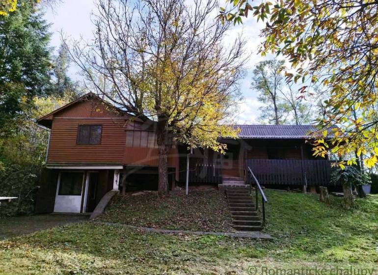 Ein Ferienhaus in Dudince, umgeben von Bäumen und üppigem Grün, ideal zum Entspannen.