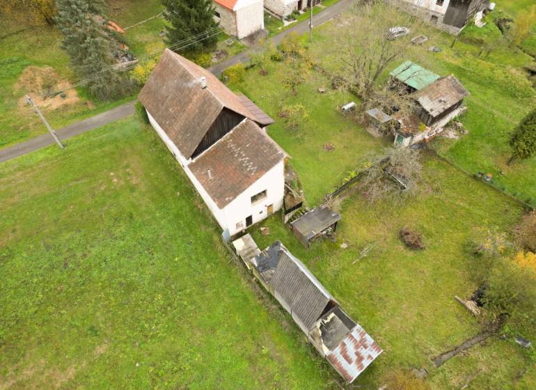 Ein Einfamilienhaus in Sklené in Sklené, umgeben von einem Garten, mit Nebengebäuden und Bäumen.