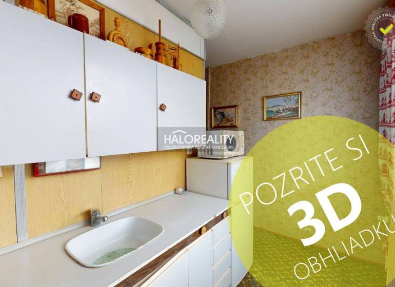 Küche in einer 3-Zimmer-Wohnung mit weißen Schränken und Bildern an den Wänden.