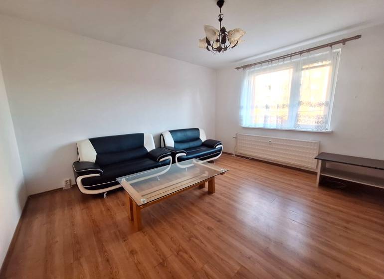Wohnzimmer in einer 3-Zimmer-Wohnung mit Sofas, Couchtisch und Holzboden.