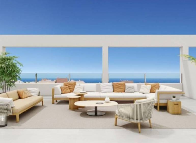 Die Terrasse der Ferienwohnung in Torrevieja mit Sitzgelegenheiten, Ozean und blauem Himmel im Hintergrund.