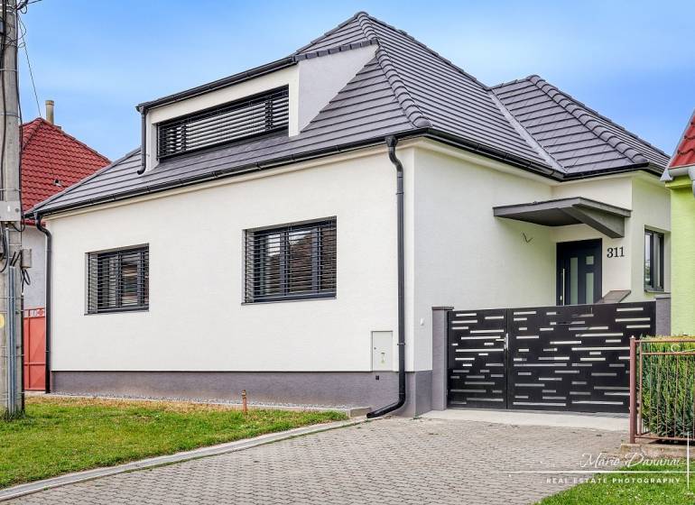 Ein Einfamilienhaus in der Orechová-Straße in Jaslovské Bohunice mit modernem Dach und Zaun.