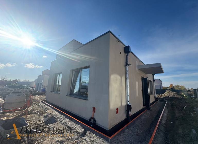 Das Äußere eines Einfamilienhauses in Hubice während des Baus, sonniges Wetter erhellt die Szene.