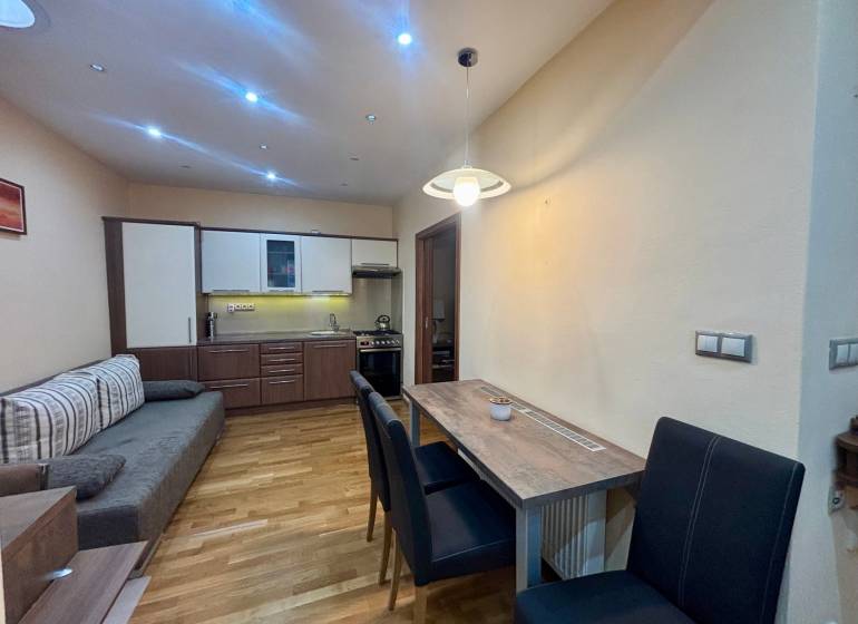 Küchenecke mit Essbereich in einer Einzimmerwohnung mit Holzboden.